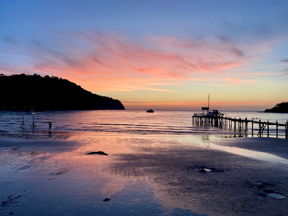 a sunset view of a pier and a body of water