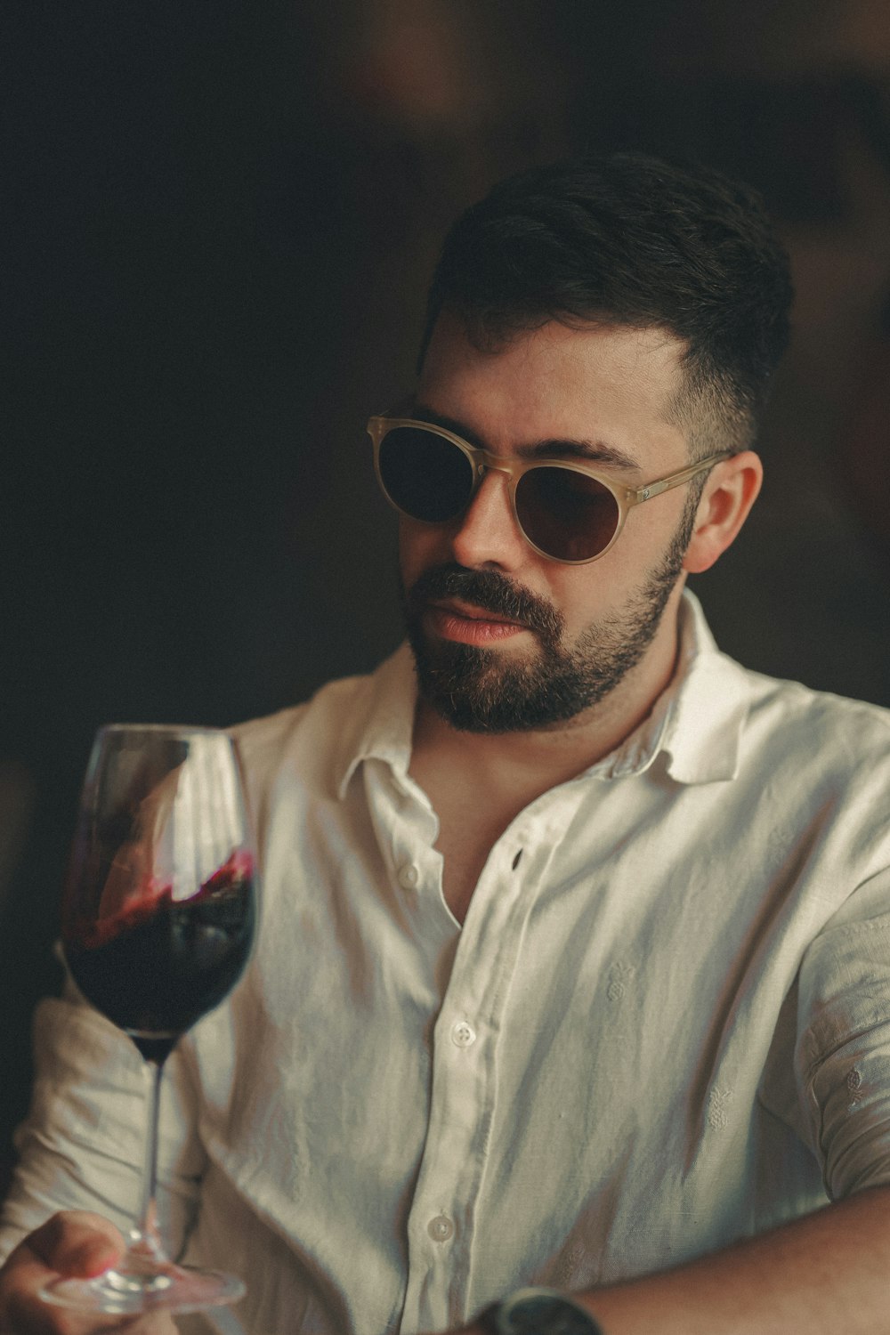 um homem segurando um copo de vinho tinto
