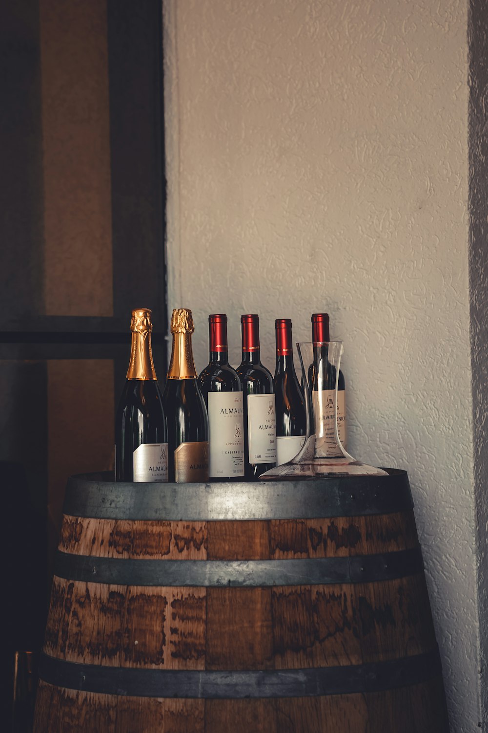 a bunch of bottles of wine sitting on top of a barrel