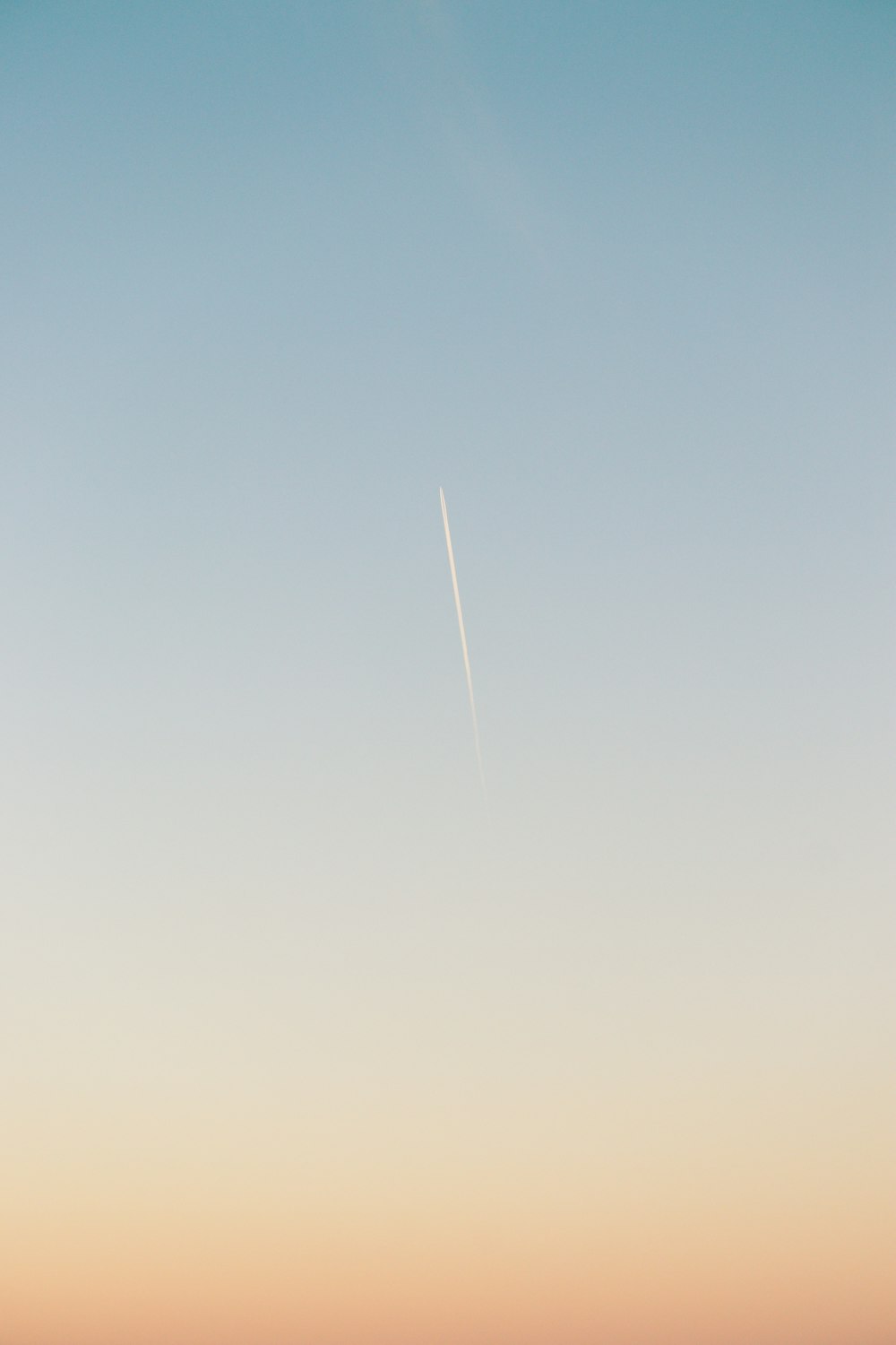a plane flying in the sky over a beach