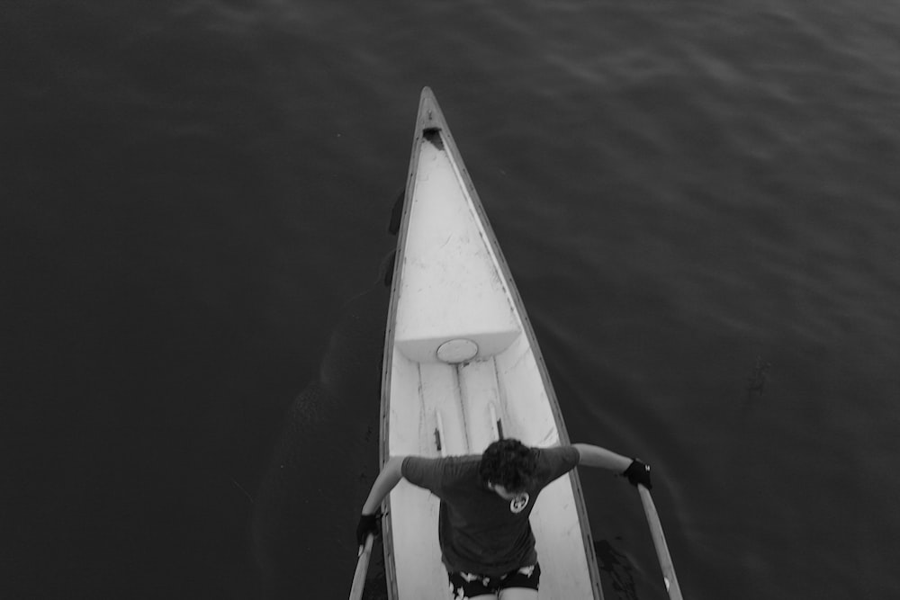 a man standing on the front of a boat in the water