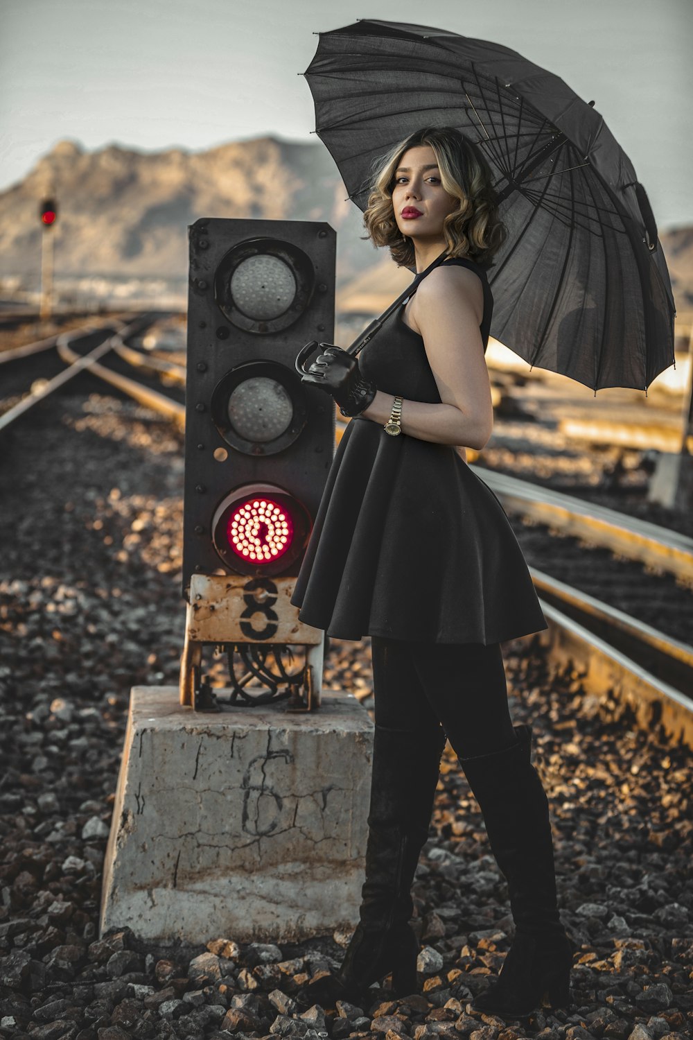 a woman in a black dress holding an umbrella