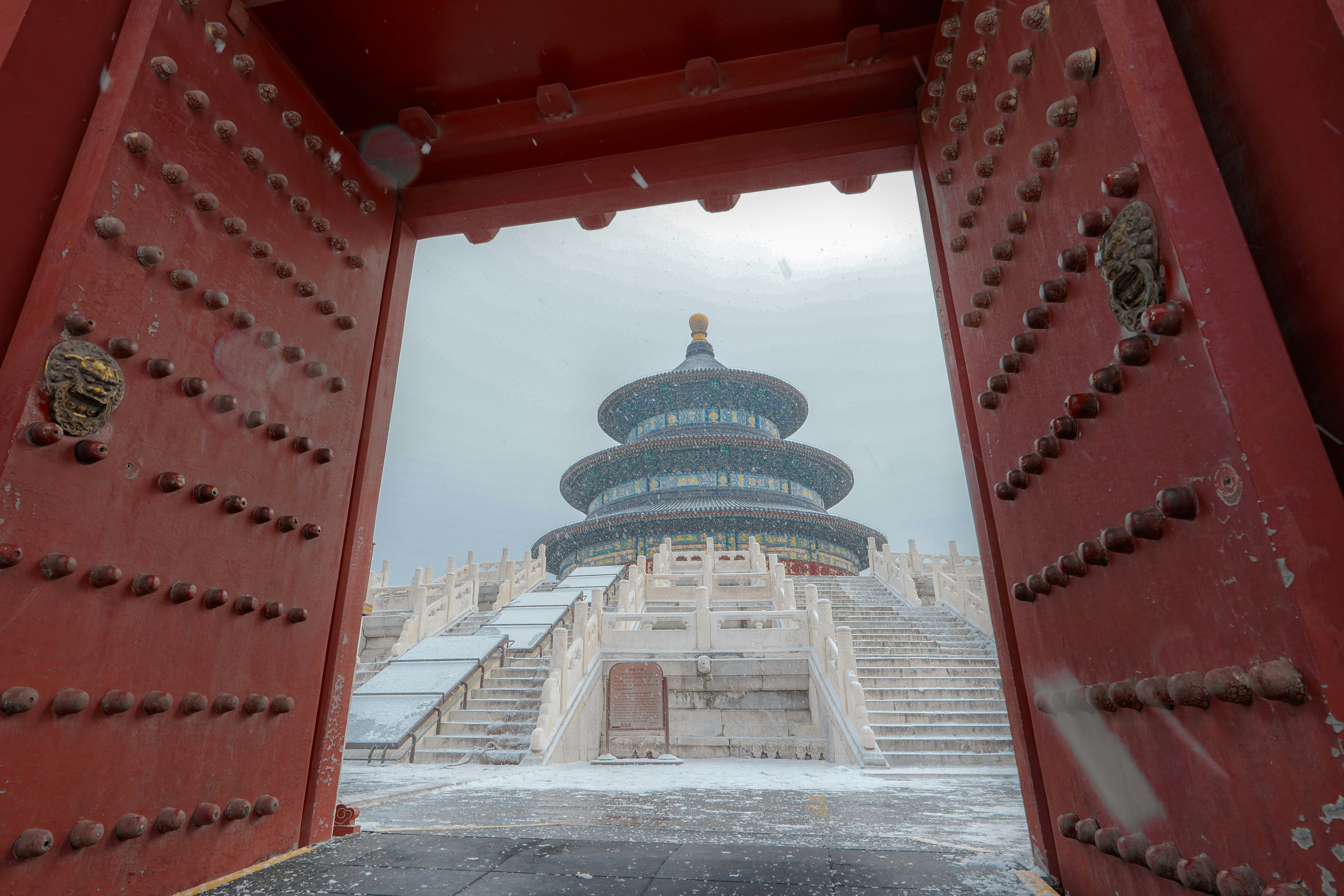 a red gate with a building in the background