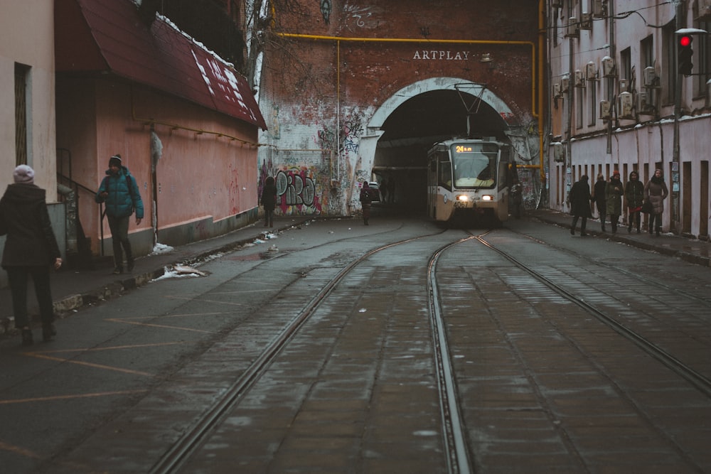 a train coming out of a tunnel in a city