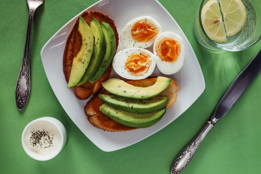 ein weißer Teller mit Eiern und Avocado