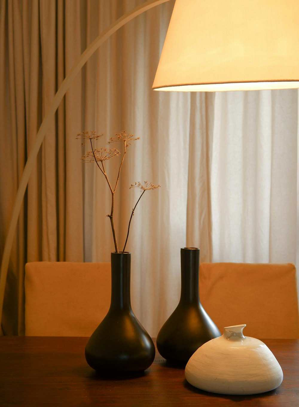 a table with two vases and a lamp on it