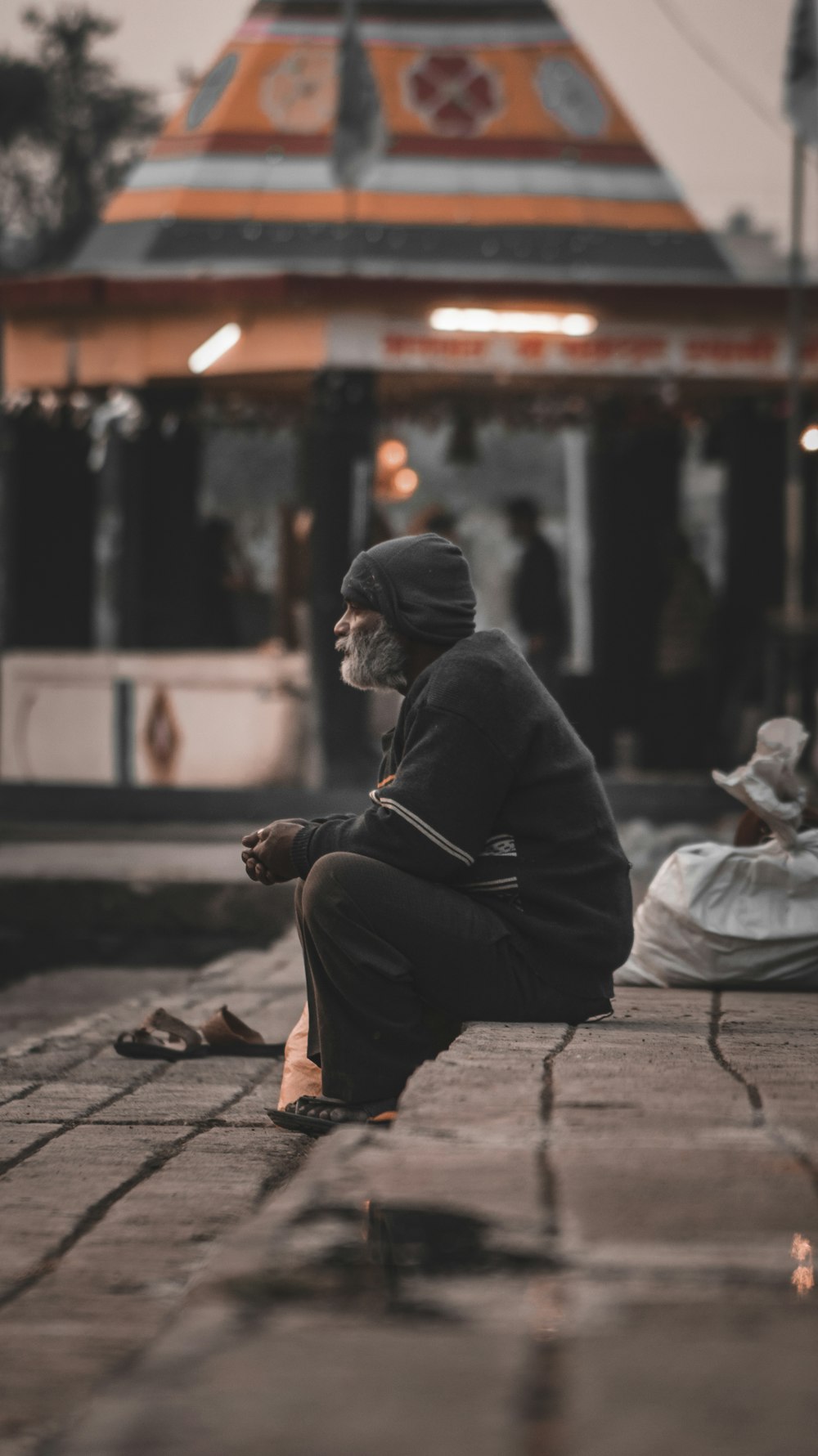 a man sitting on the ground in front of a train