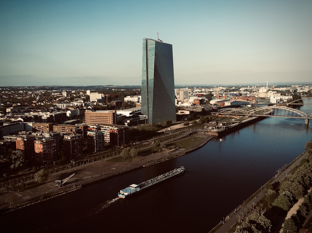 a boat traveling down a river next to a tall building