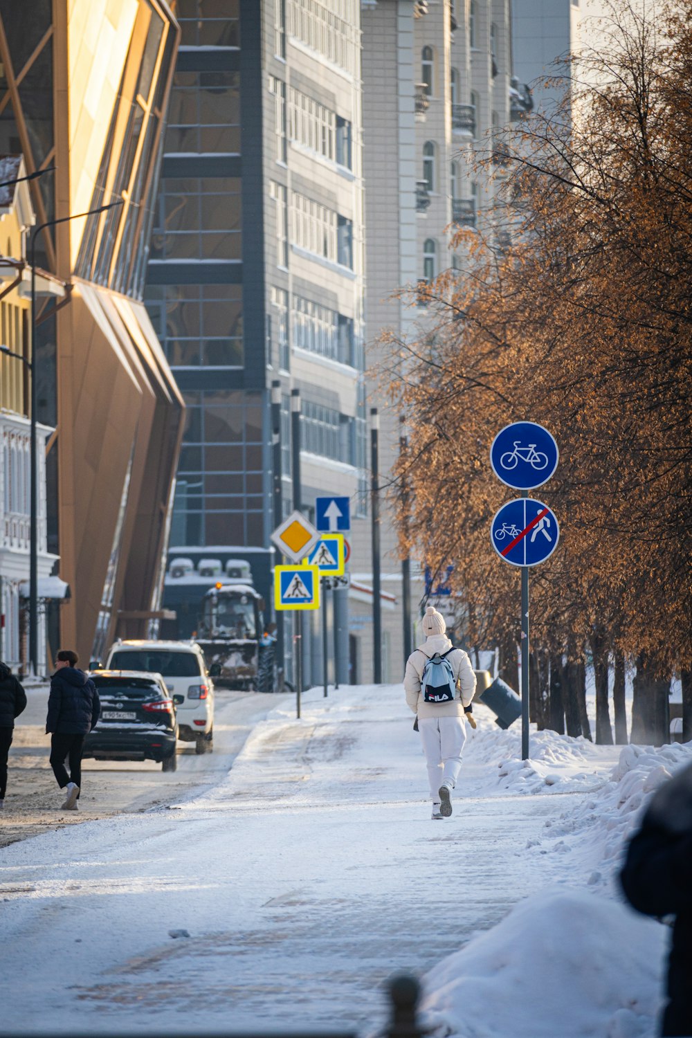 a woman walking down a snow covered street