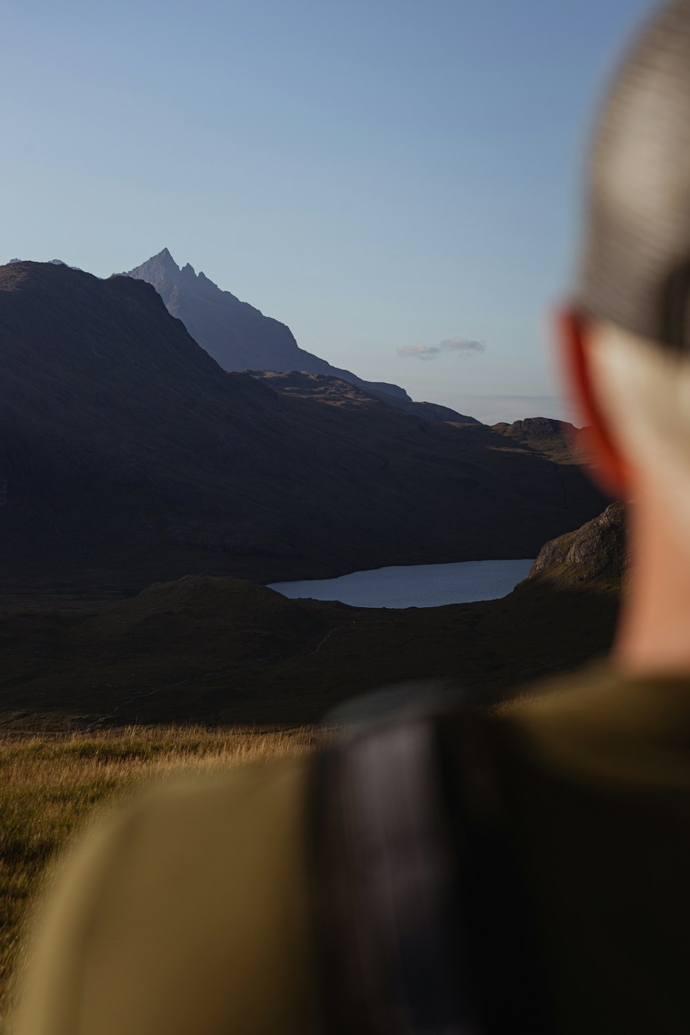 Un hombre está mirando un lago de montaña