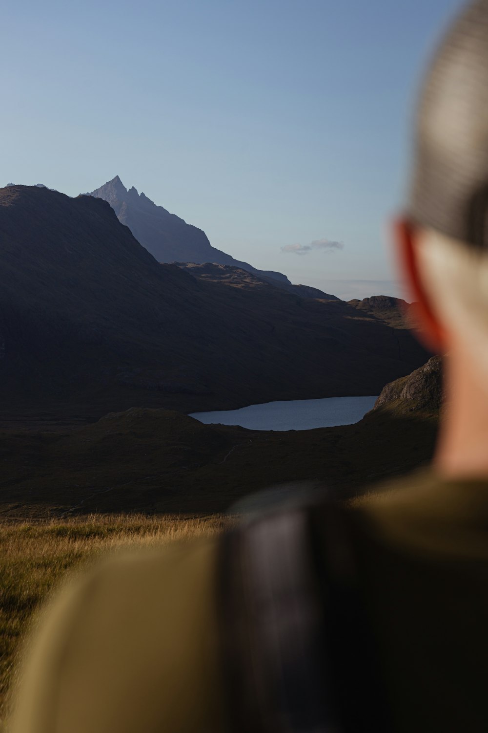 a man is looking at a mountain lake