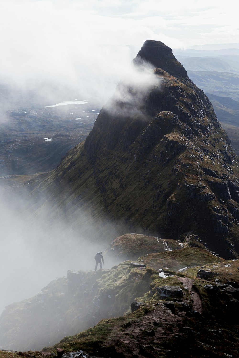 a man standing on top of a tall mountain