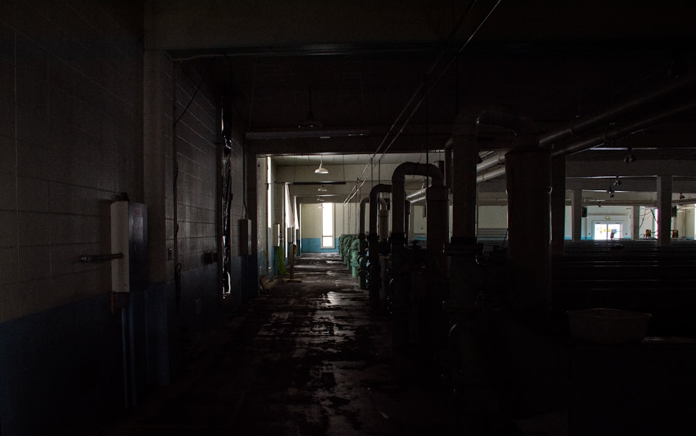 a dark hallway with a bunch of pipes