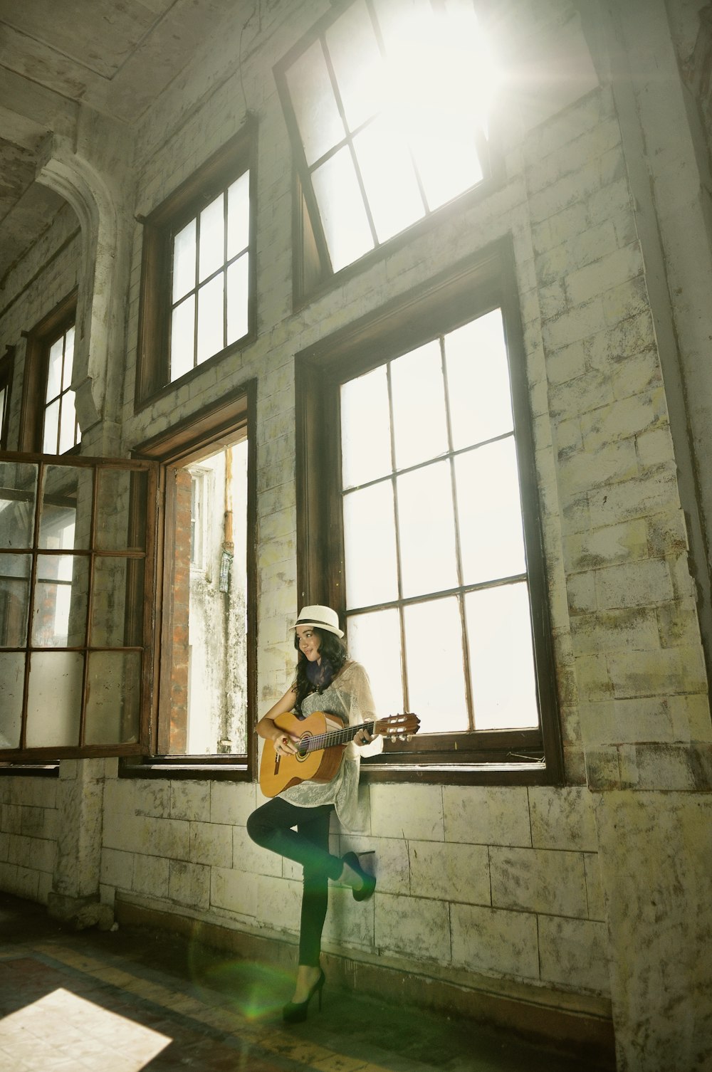 a person with a guitar standing in front of a window