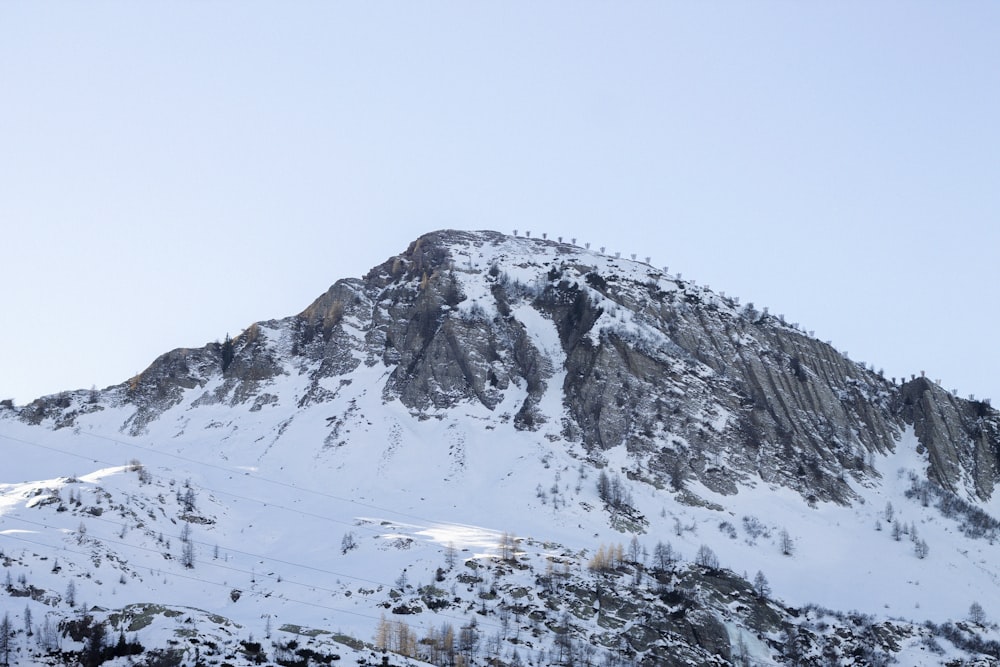 a mountain covered in snow with a sky background