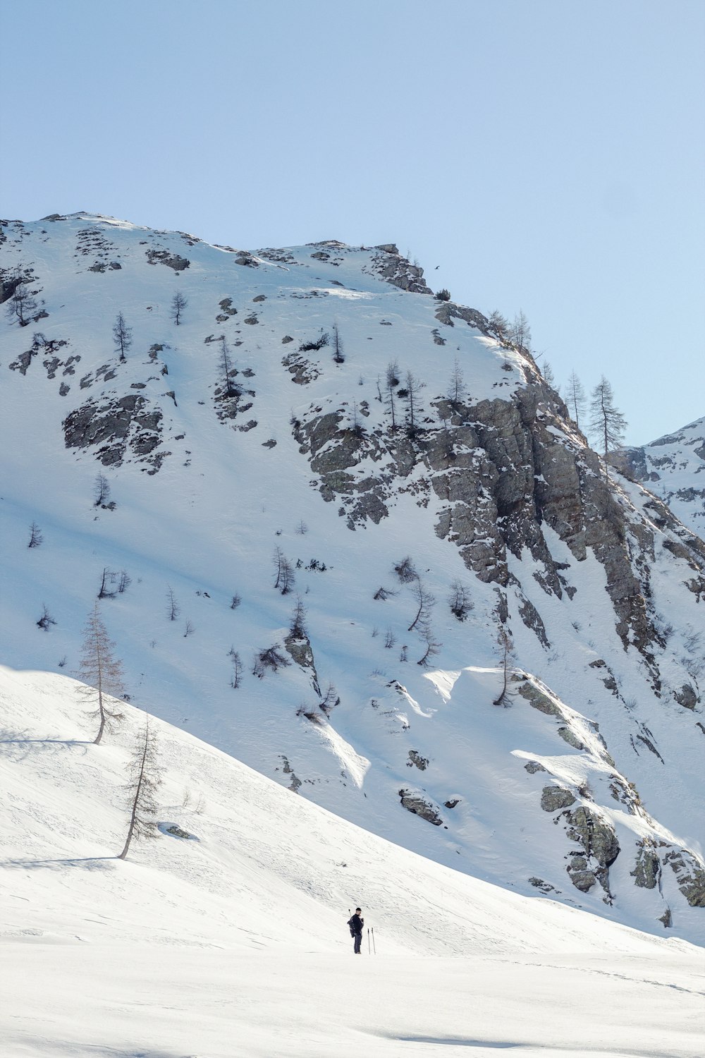 a person walking up the side of a snow covered mountain