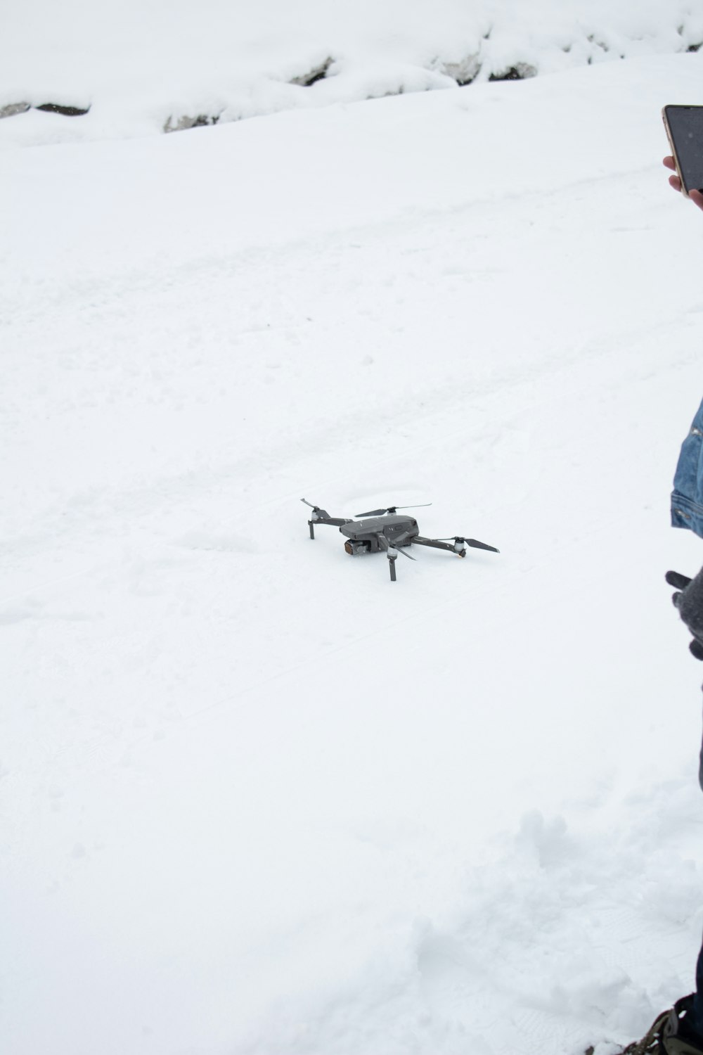 eine Person, die mit einer Fernbedienung im Schnee steht