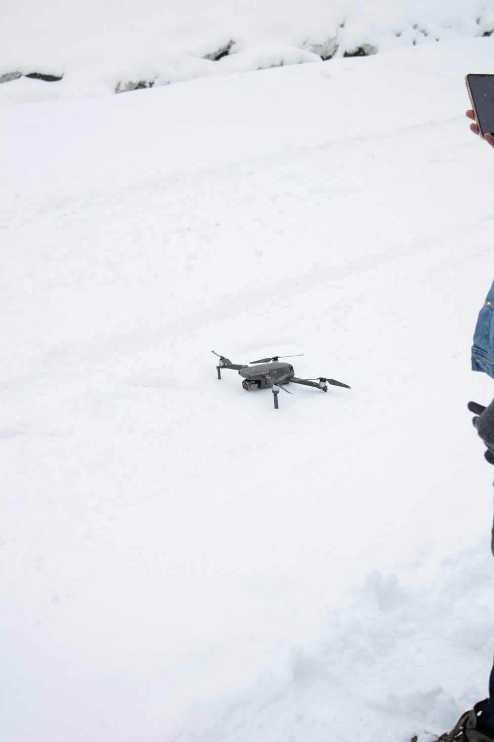 a person standing in the snow with a remote control