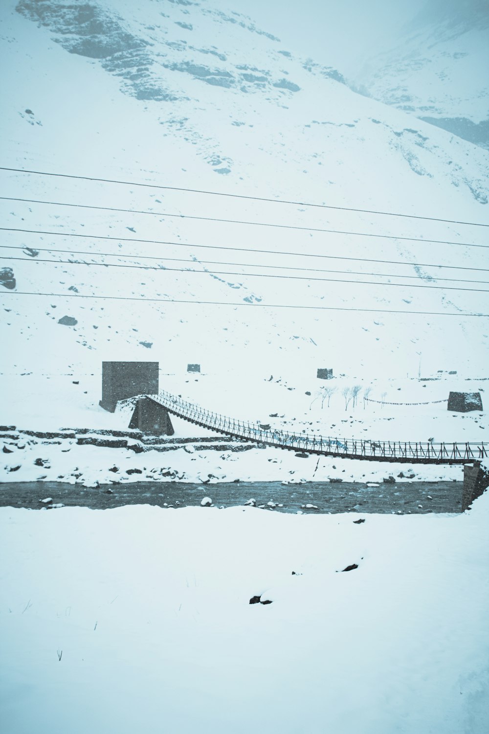 a snow covered ski slope with a ski lift in the background