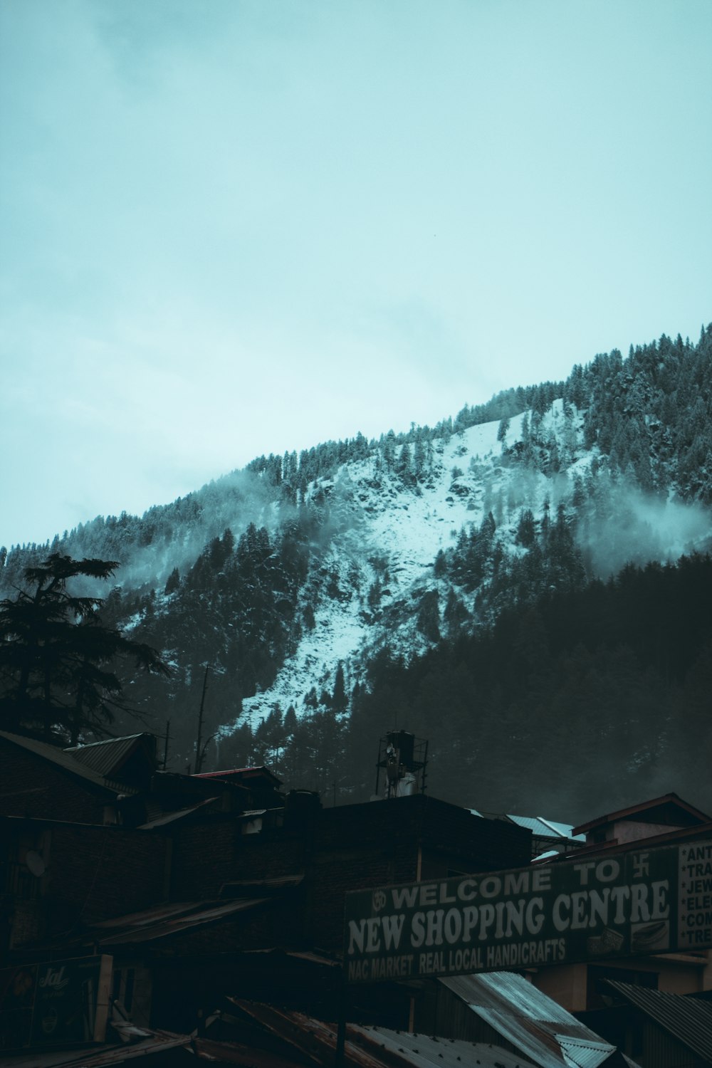 a mountain covered in snow next to buildings