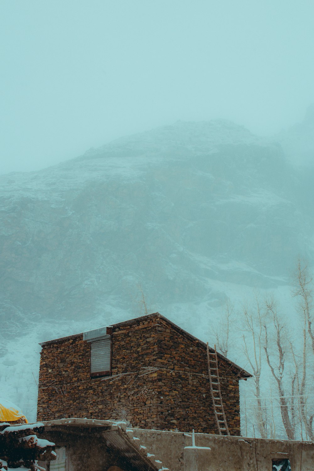 a building with a yellow umbrella in front of a mountain