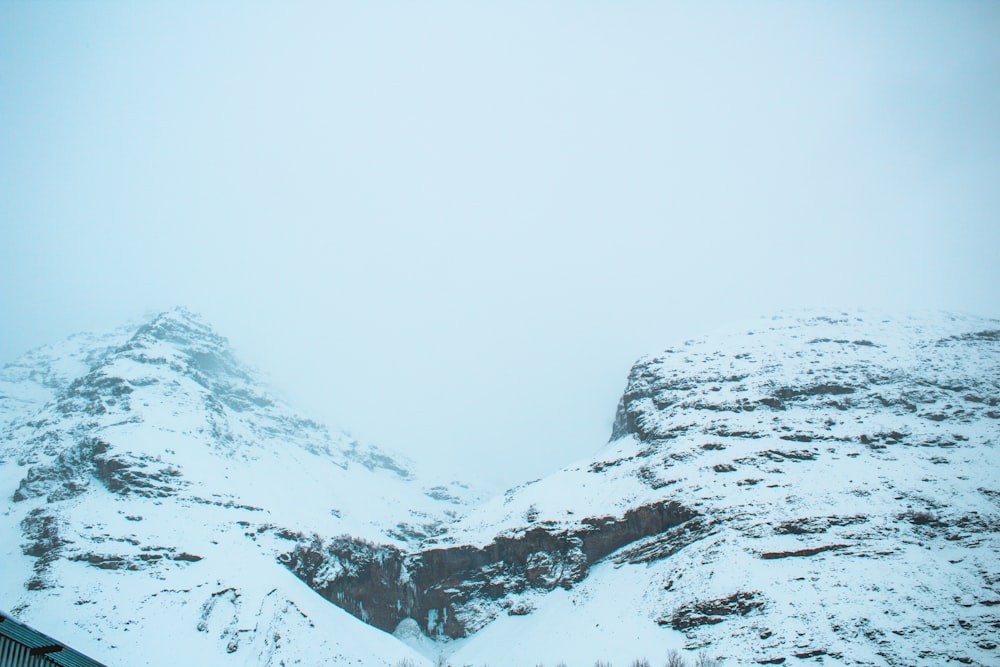 a mountain covered in snow with a sky background