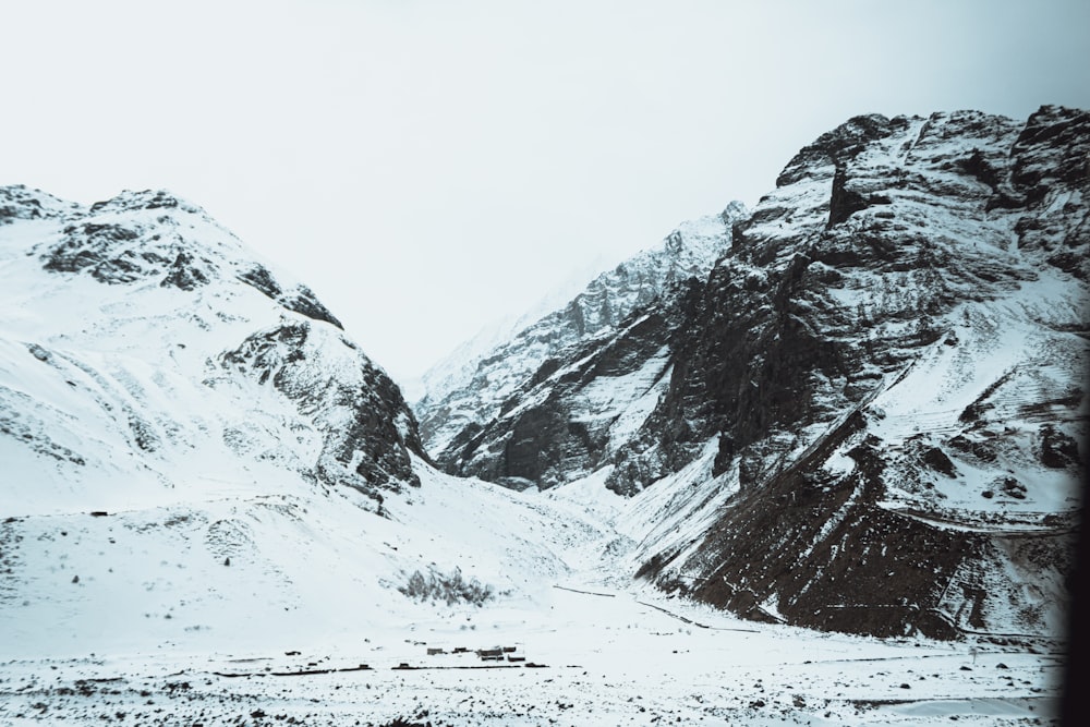 a snow covered mountain range with a road in the foreground