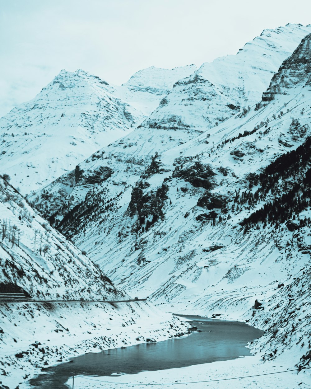 eine schneebedeckte Bergkette mit einem See im Vordergrund