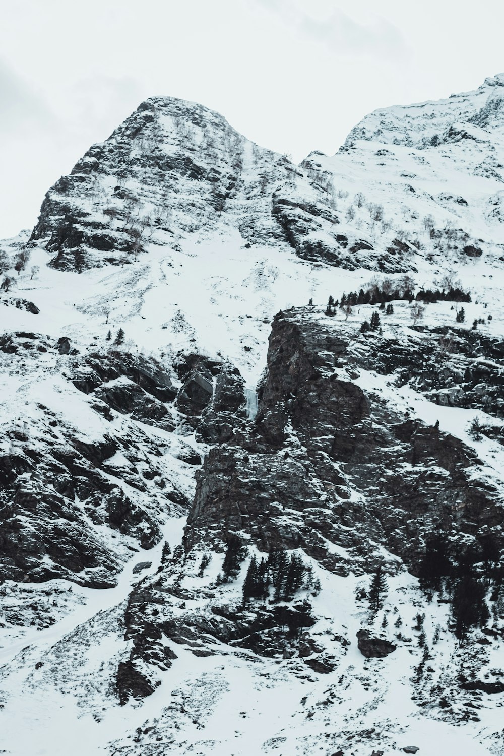 a mountain covered in snow with a sky background