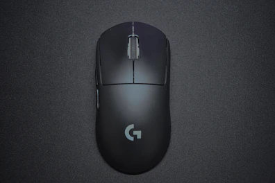 Sleek black gaming mouse with empire gold logo on a distressed dark surface.