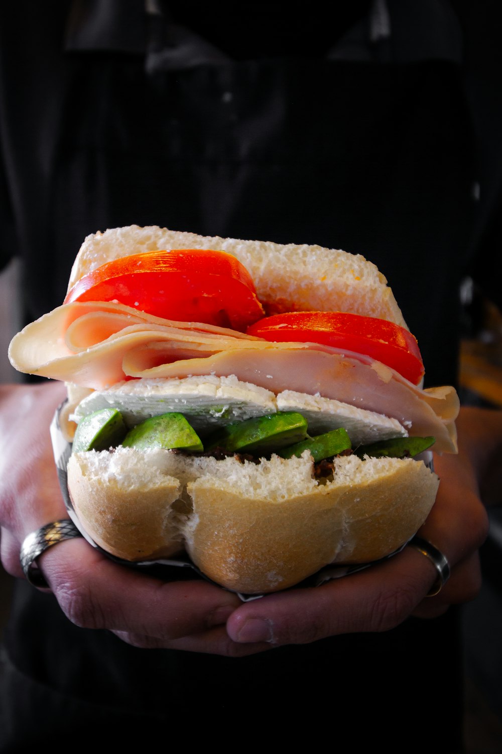 a person holding a sandwich in their hands