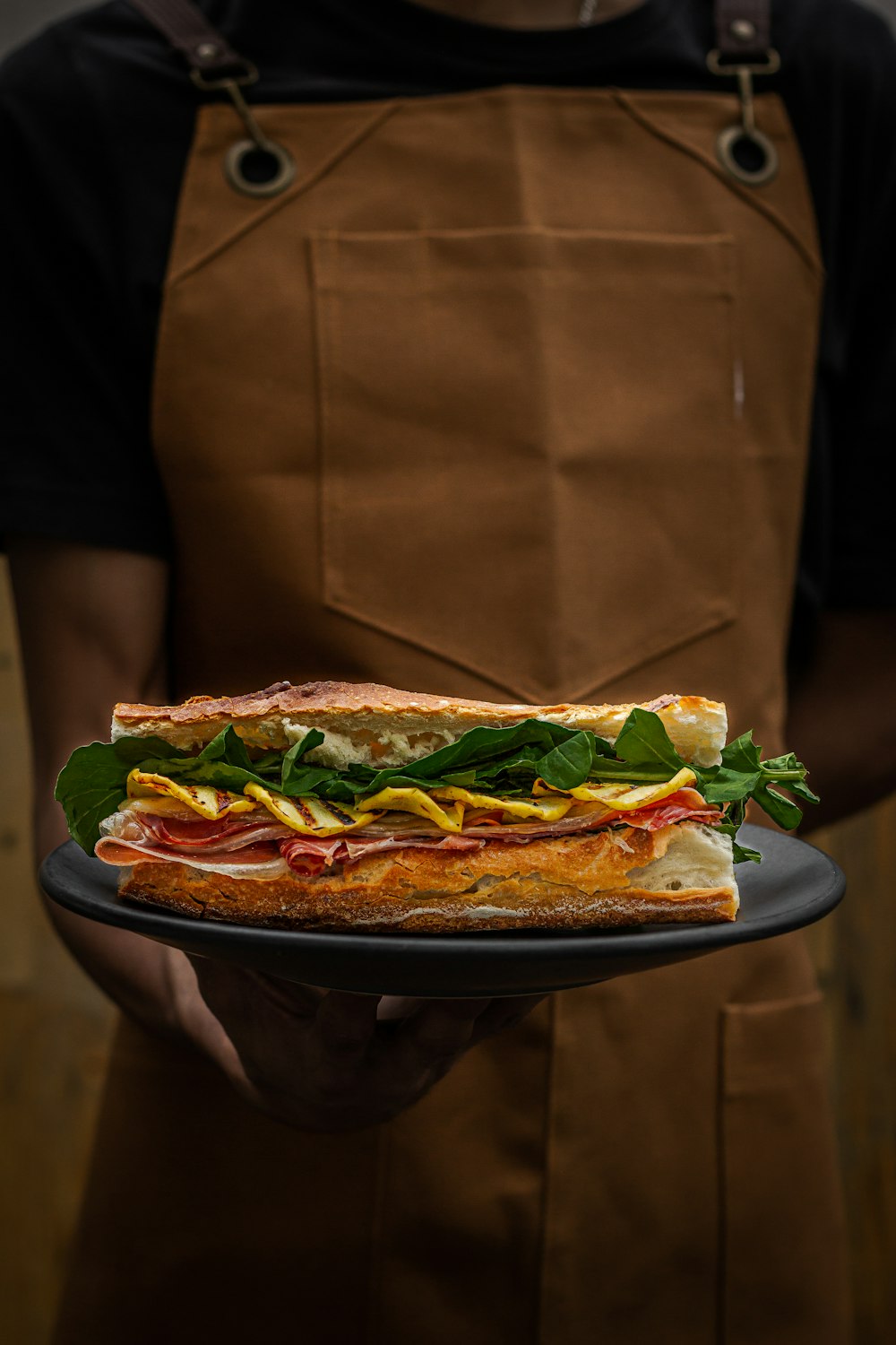 a person holding a plate with a sandwich on it