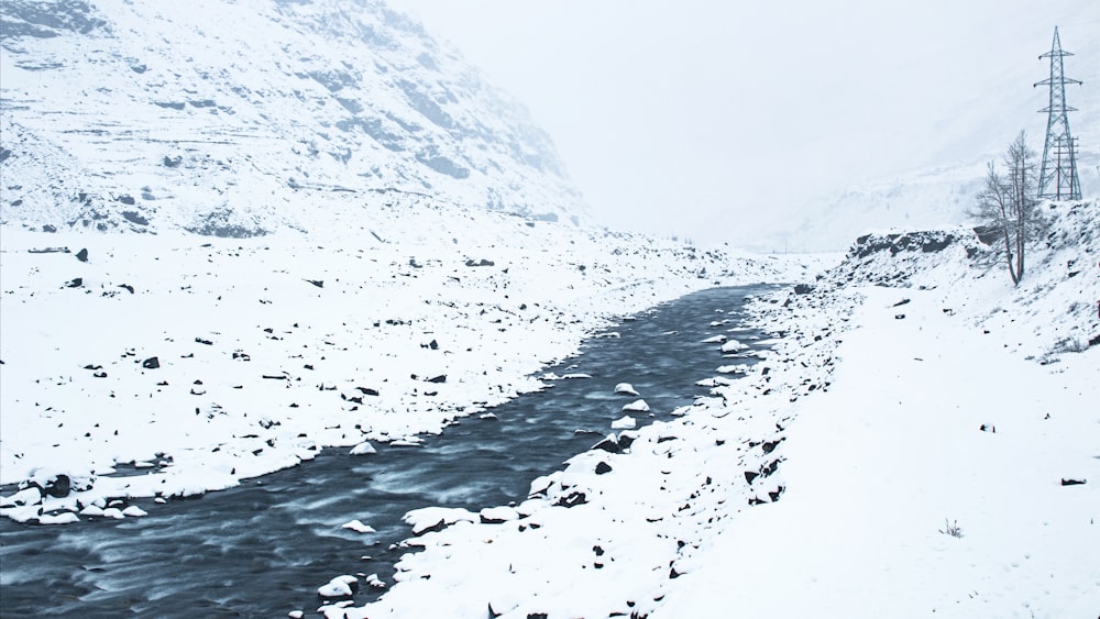 Ein Fluss, der durch einen schneebedeckten Berghang fließt