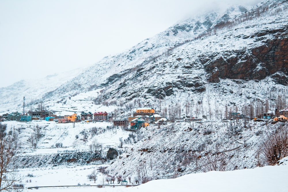 a snow covered mountain with a village in the distance