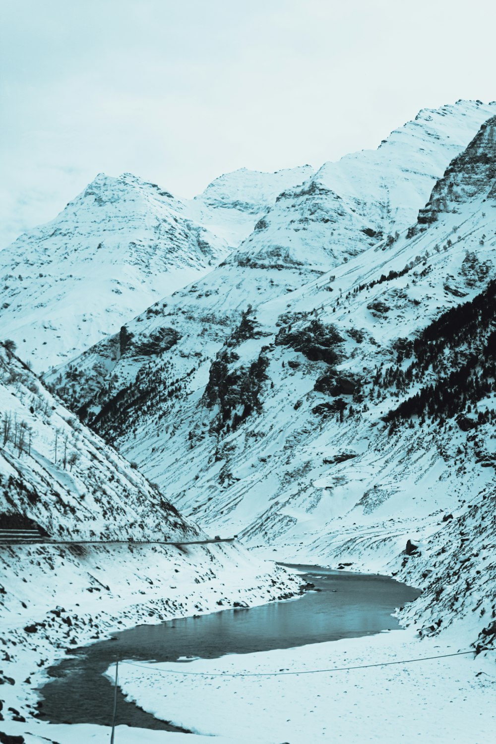 a snow covered mountain with a lake in the foreground