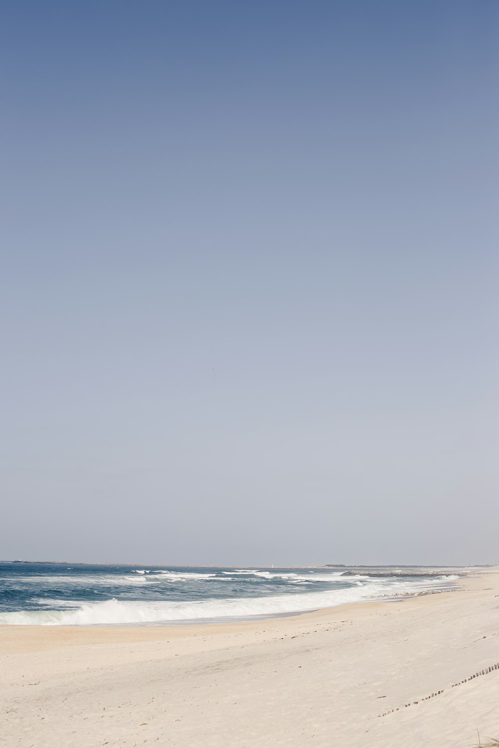 a person walking on a beach with a surfboard