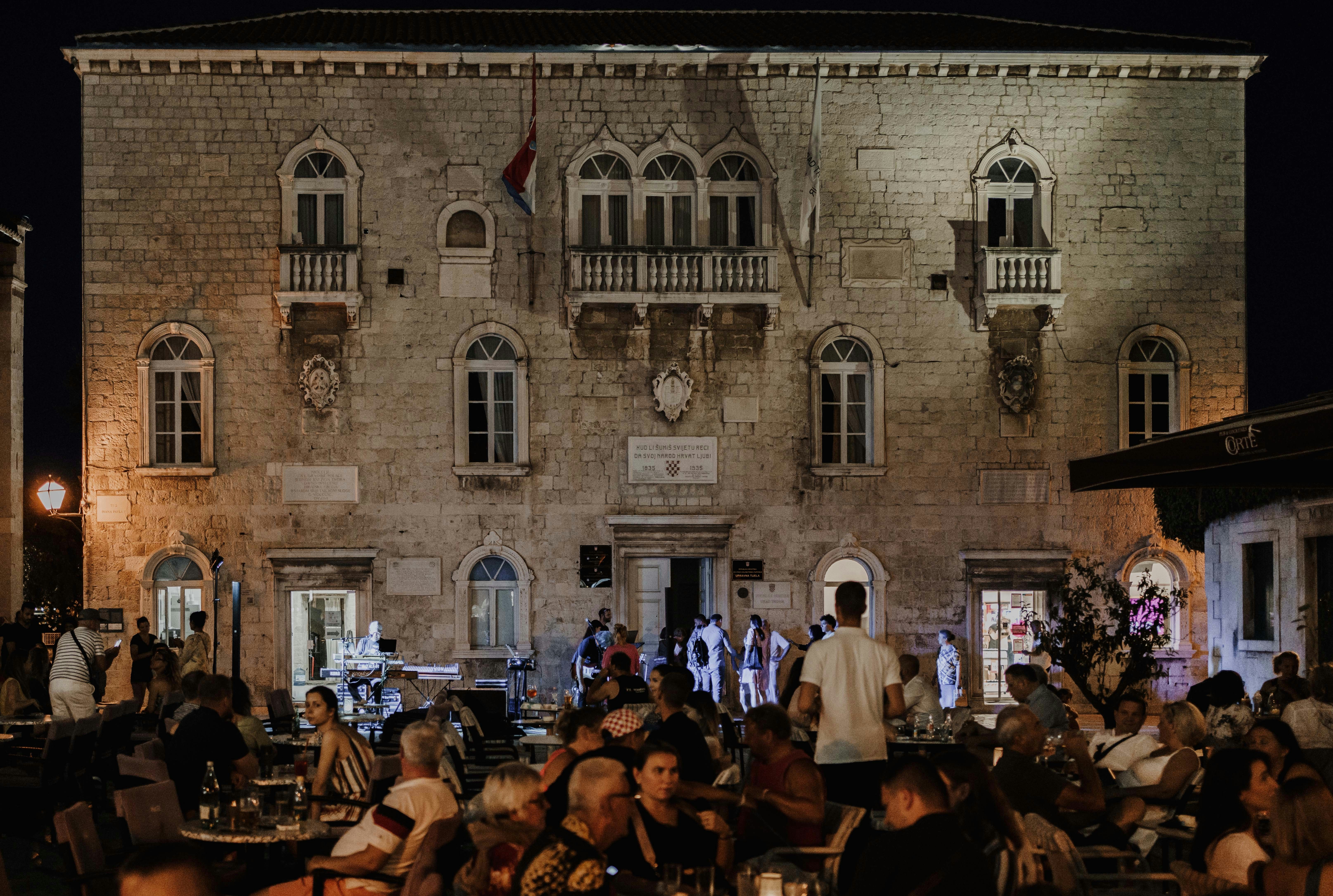 a group of people sitting at tables in front of a building