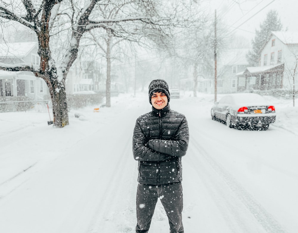 a man standing in the middle of a snowy street