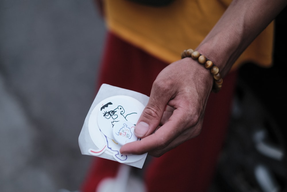 a person holding a paper with a drawing on it