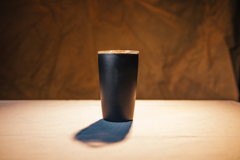 a black cup sitting on top of a table