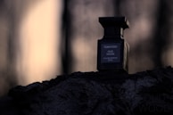 A luxurious oud bottle surrounded by delicate oud wood chips and soft golden light.