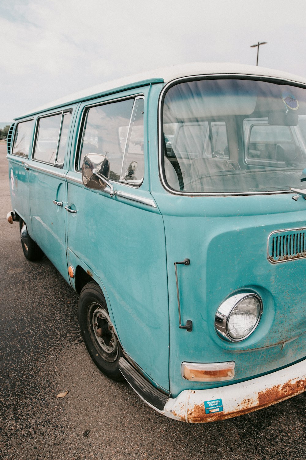 an old blue van parked in a parking lot