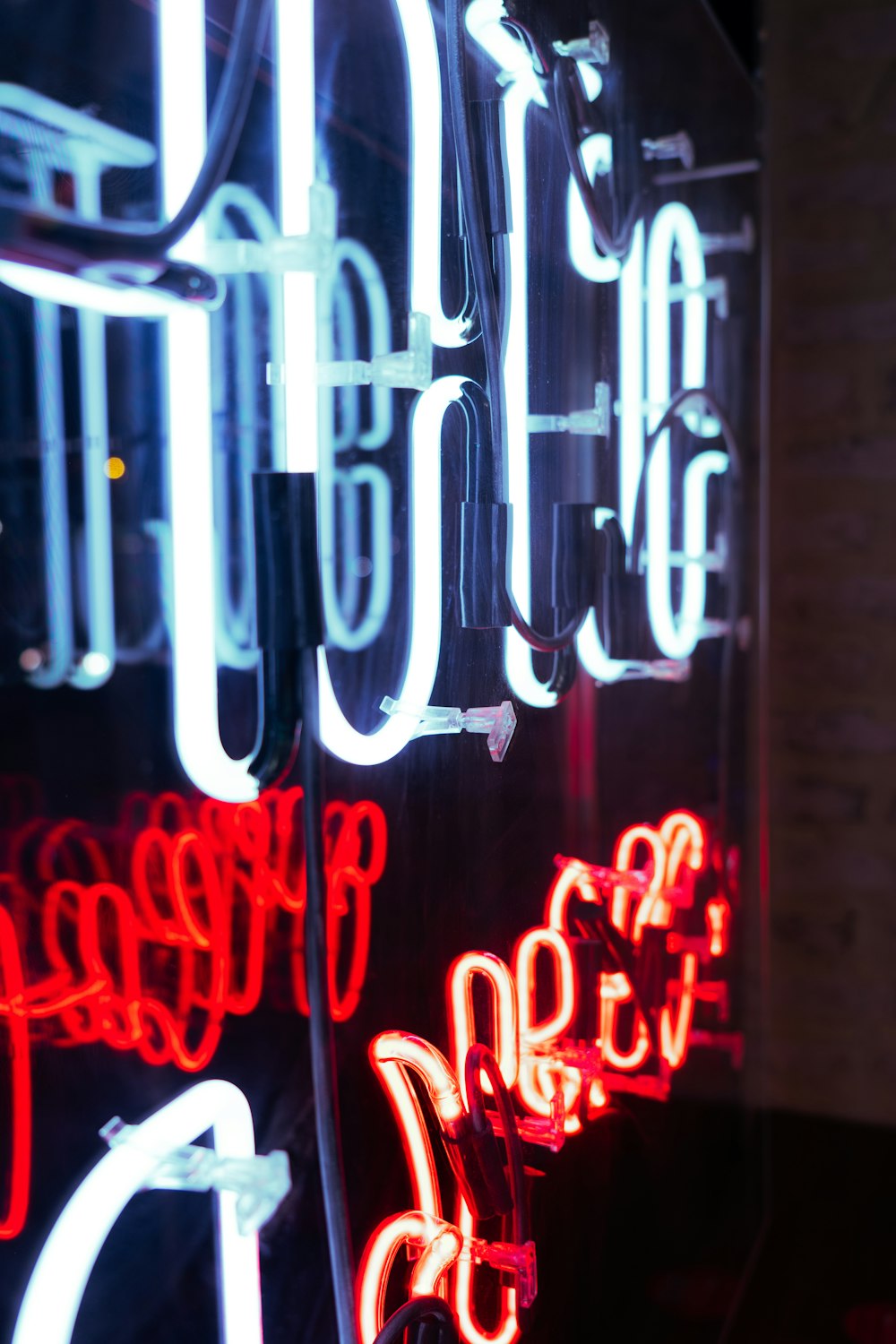 a group of neon signs sitting on the side of a building