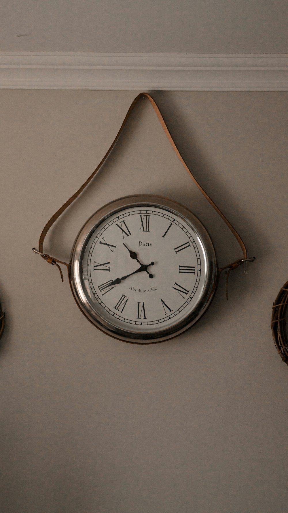 a clock hanging on the wall next to two clocks