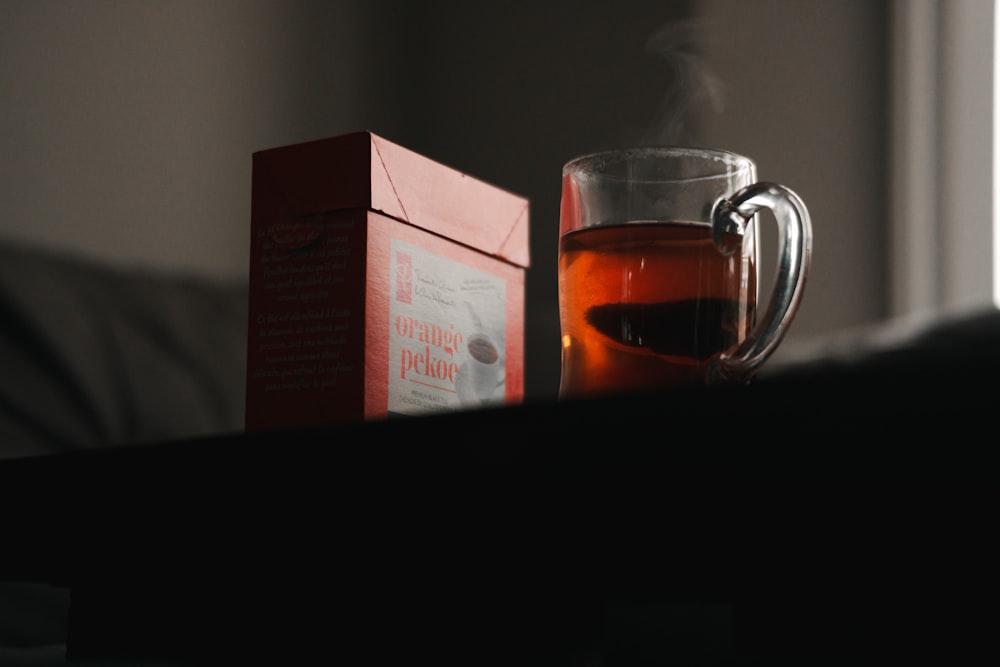 a cup of tea next to a box of cigarettes