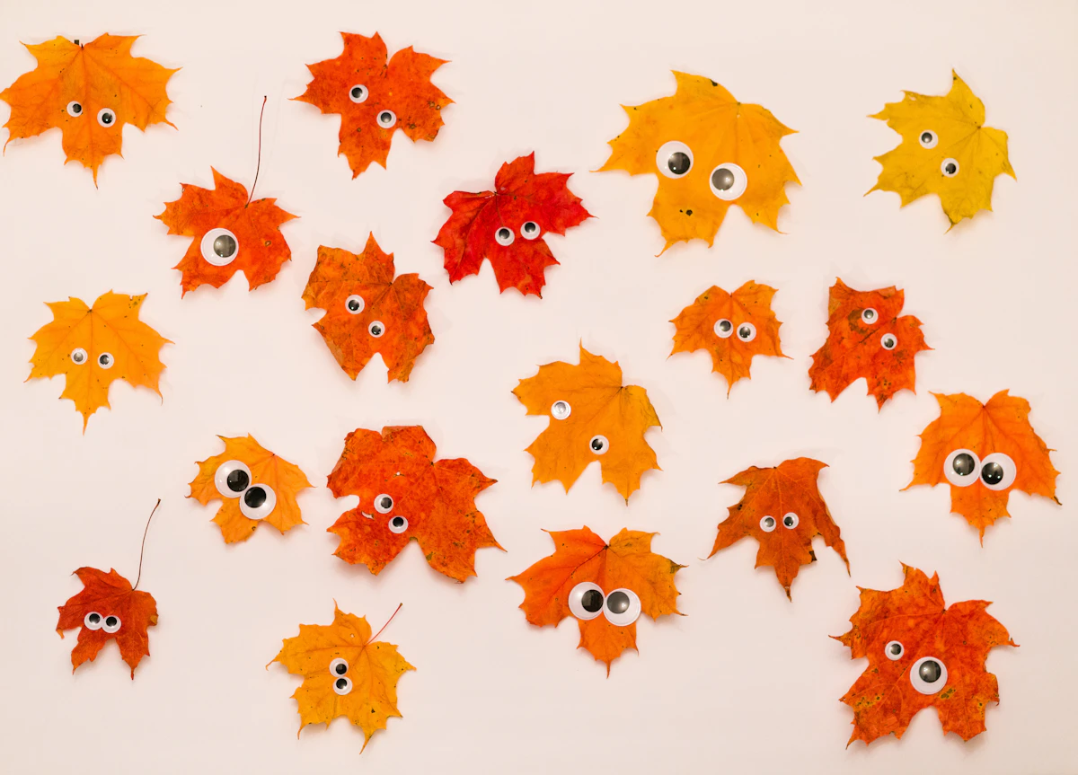 Orange and yellow paper leaves with googly eyes