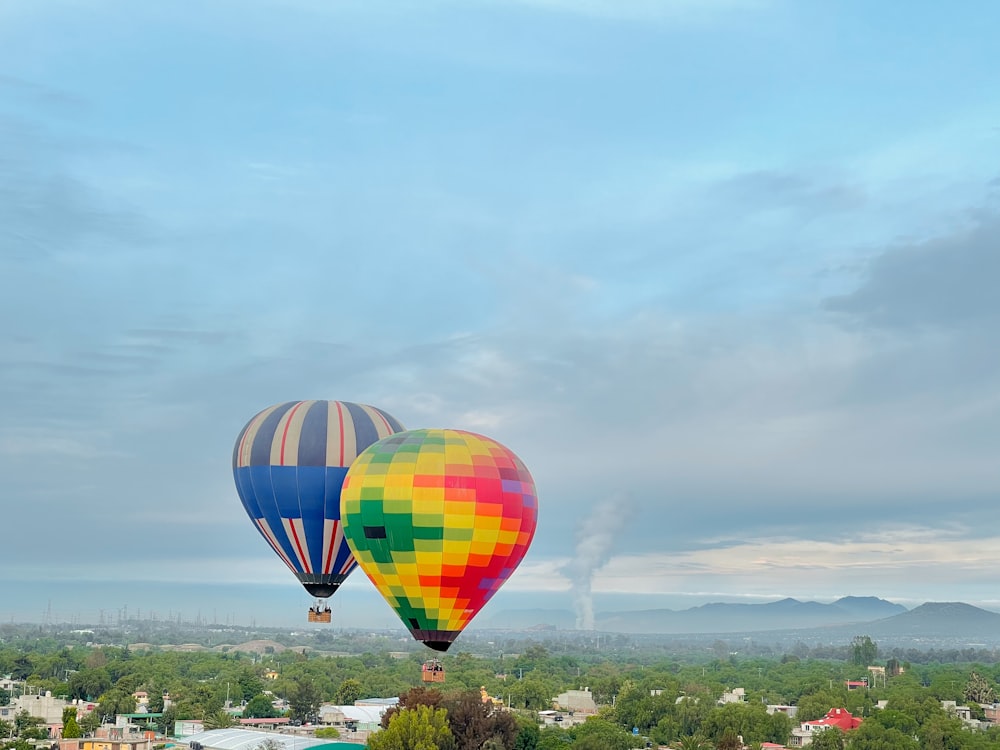 a couple of hot air balloons flying over a city