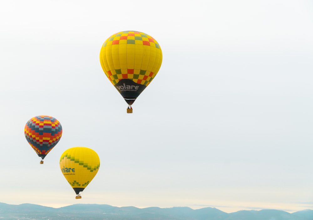 three hot air balloons flying in the sky
