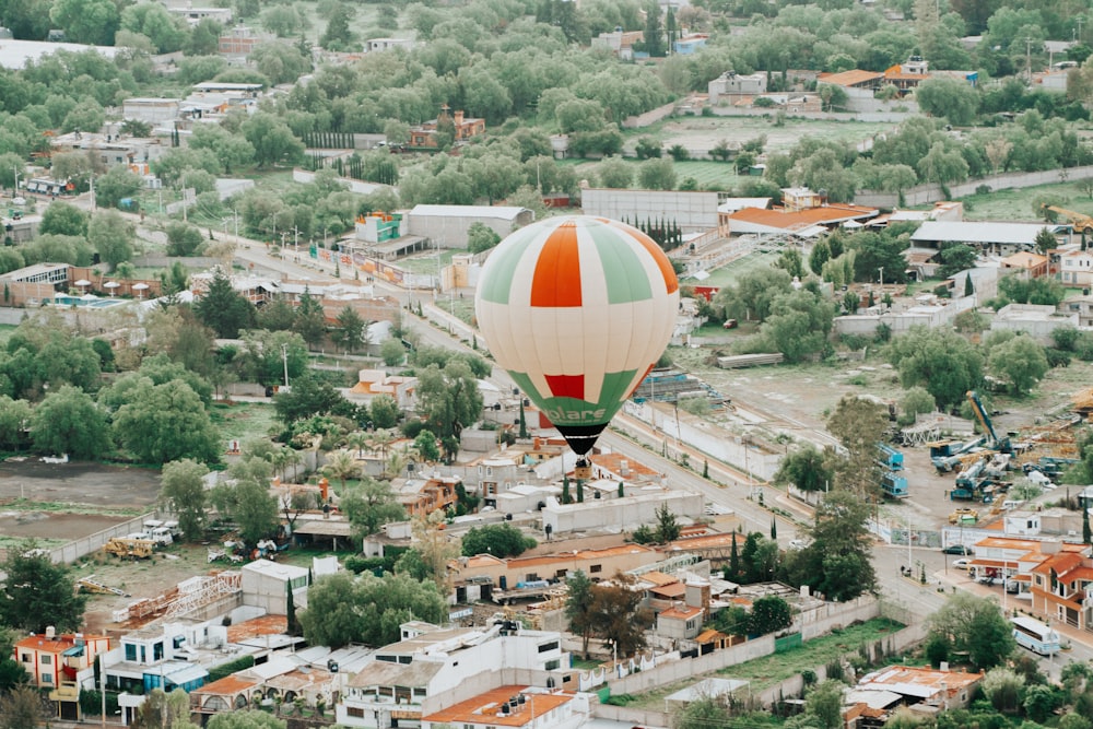 a hot air balloon flying over a small town