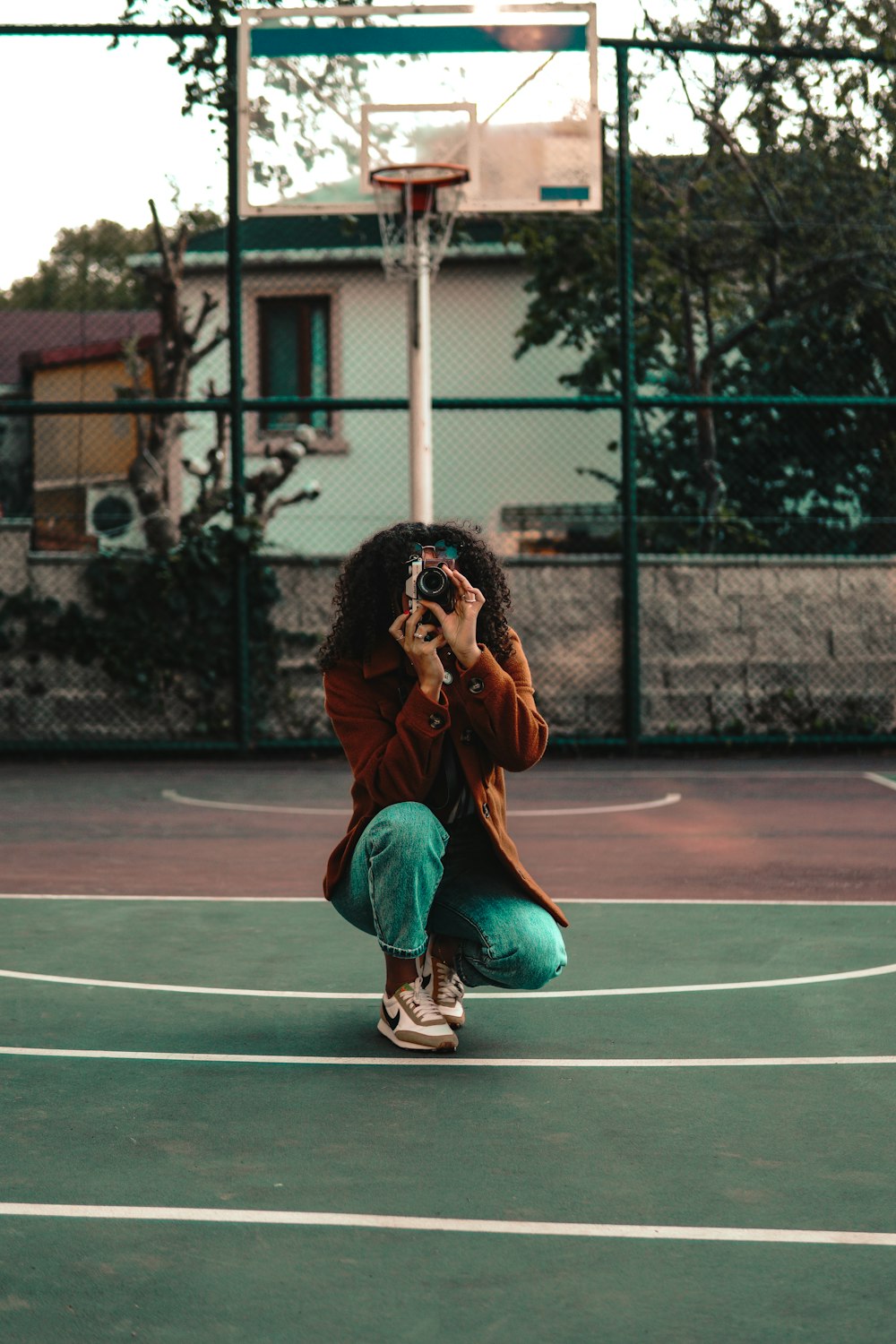 a woman taking a picture of herself on a basketball court